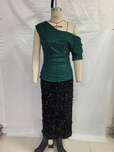 Dettaglio del top monospalla con paillettes verde scuro e gonna nera scintillante