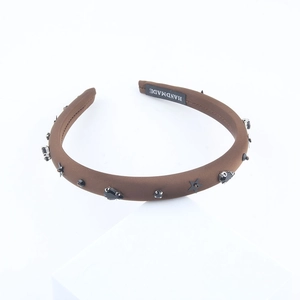 Brown fabric headband with black gemstones and stars on a white background