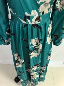 Détails de robe verte à col en V avec imprimé floral de papillon et taille haute plissée