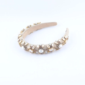Close-up of champagne padded headband with clustered rhinestones and pearls