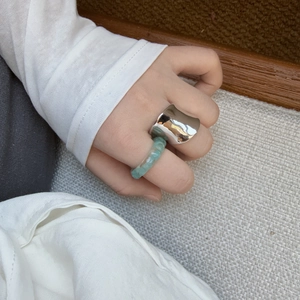 Irregular silver metal ring and green marble resin ring set worn by a model