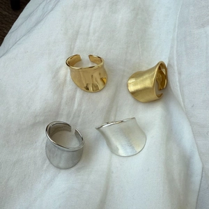 Detail of wide open rings in gold and silver with matte brushed and polished finishes