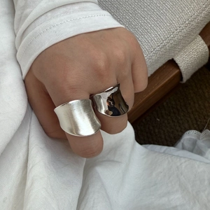 Close-up of minimalist silver wide rings in brushed matte and polished glossy finishes