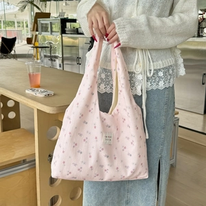 Detail view of pink floral pattern and textile label on cotton tote shoulder bag