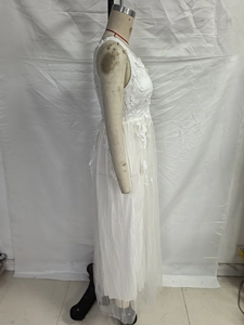 Detail of white sleeveless lace wedding dress with intricate floral embroidery and tulle