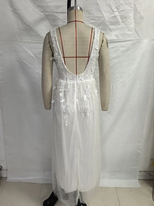Detail showing backless deep V-neck and floral lace appliques on white tulle dress