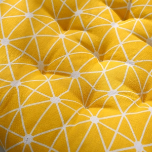 Bright yellow round chair cushion with white geometric star pattern in linen fabric