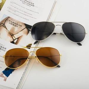 Classic aviator sunglasses with silver and gold metal frames on a fashion magazine