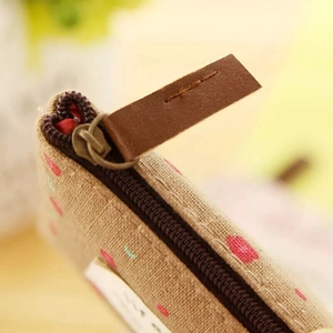 Floral canvas coin purse with pink dots and retro bronze zipper on beige fabric