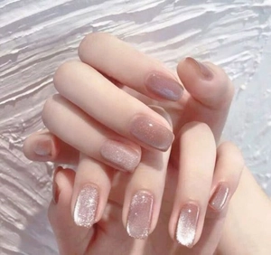Détails d'ongles amande œil de chat rose poudré et mauve avec reflets argentés brillants