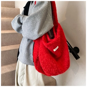 Macro shot of a red plush tote bag showing fluffy faux fur texture and white woven label