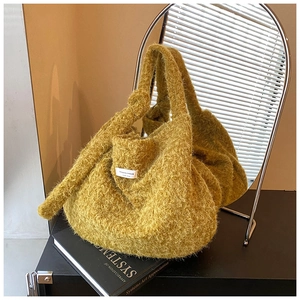 Detail of mustard green faux fur tote bag showing plush texture and woven brand label