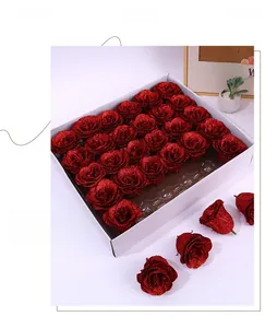Macro shot of 25 red glitter artificial roses in a white gift box with floral details
