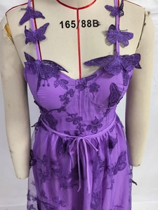 Detail of purple tulle dress showing 3D butterfly appliques and floral embroidery