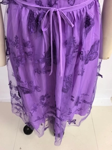 Detail of purple tulle dress featuring intricate butterfly embroidery and adjustable waist tie