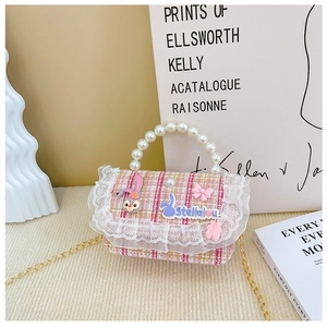 Detailed macro of pink tweed kids handbag with pearl handle and golden chain