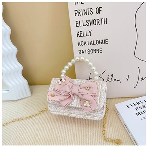 Detail of pink tweed girl's handbag with large silk bow, pearls, and gold chain strap