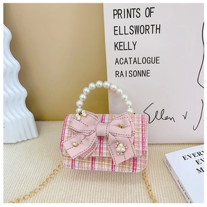 Detail of pink tweed texture with ribbon bow, pearl handle, and golden chain strap