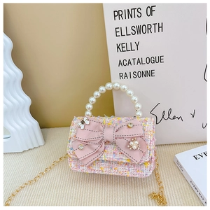 Detailed view of pink tweed mini bag featuring pearl handle and satin bow decoration