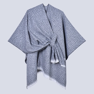 Schicker Strickponcho in Graumeliert mit Wickelknoten-Design und weißen Fransen am Saum