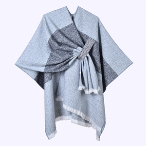 Detail of blue-grey knit shawl with tassel hem and geometric color block design