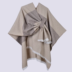 Detail view of earth tone striped shawl with soft knit texture and white fringe tassels