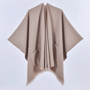 Detailed view of women's knitted shawl featuring large side pockets and fringed edges