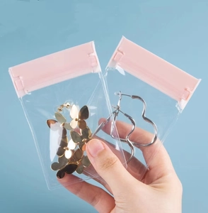 Close-up of small transparent jewelry storage bags with pink zip lock held in hand