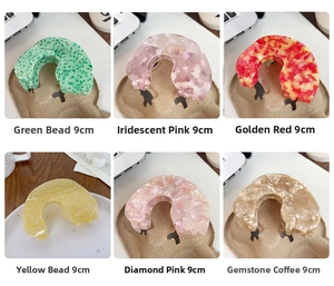 Detail view of 9cm U-shaped acetate hair claws in six varied marbled resin colors