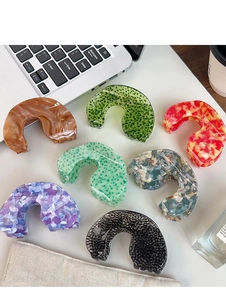 Detailed set of 7 acetate claw clips with marble and floral patterns on a white desk