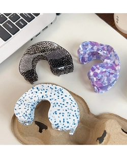 Three acetate hair claws in black marble, purple petal, and blue floral patterns