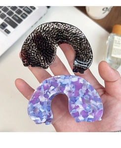 Close-up of tortoise shell and blue marble acetate hair claws in a lifestyle setting