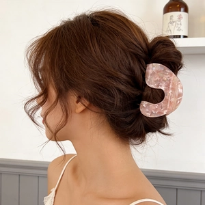 Pink marble acetate hair claw clip for elegant updo hairstyles on a female model
