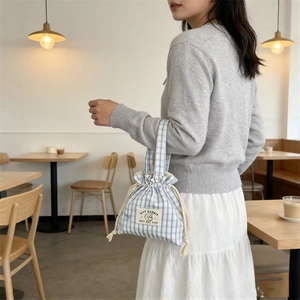 Détail du sac à cordon à carreaux bleus et blancs avec broderie lapin et corde en coton