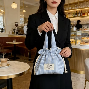 Détail du sac en toile à rayures bleues avec broderie lapin mignonne et cordon serré