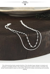 Detail of silver double-layered snake chain bracelet with clover leaf metal sequins