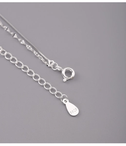 Macro detail of 925 sterling silver snake chain with spring clasp and S925 engraved tag