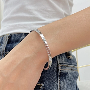 Minimalist silver geometric bracelet with rectangular links worn on wrist for women