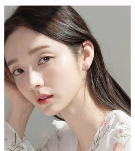 Close-up of S925 silver butterfly stud earring with pink zircon on a female model's ear