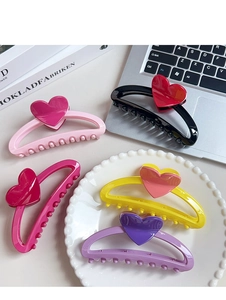 Detail showing high-gloss candy-colored heart hair claws in five vibrant colors
