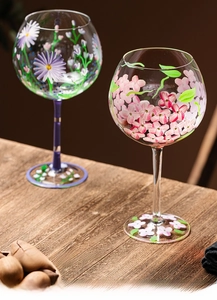 Detail of hand-painted floral wine glasses with daisy and cherry blossom patterns