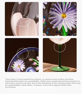 Macro detail of hand-painted floral wine glass with purple daisies and green stem