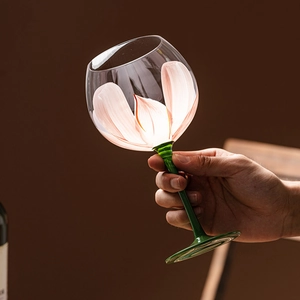 Artistic hand-painted floral wine glass with pink petals and green stem handle