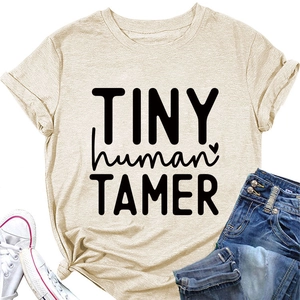 Flat lay of beige cotton t-shirt with Tiny Human Tamer print and denim shorts