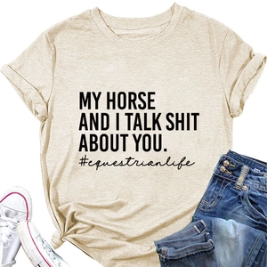 Detail des Reitsport-Slogandrucks auf beigem Baumwoll-T-Shirt mit Jeans und Schuhen