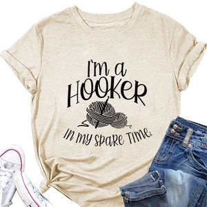 Flat lay of beige cotton T-shirt featuring crochet hobby print and blue jeans