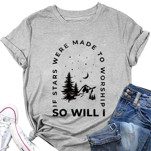 Flat lay of gray crewneck T-shirt with mountain and star print beside jeans and shoes