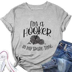 Flat lay of gray T-shirt with 'I'm a HOOKER' print styled with jeans and white sneakers