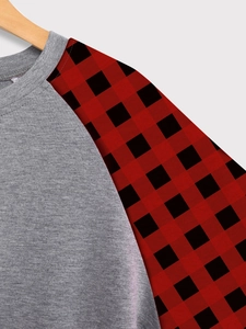 Détail du sweat gris avec manches raglan à carreaux buffalo et col rond en maille