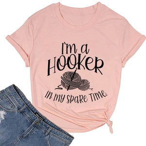 Pink cotton t-shirt detail showing a crochet graphic and spare time quote with tie-knot hem